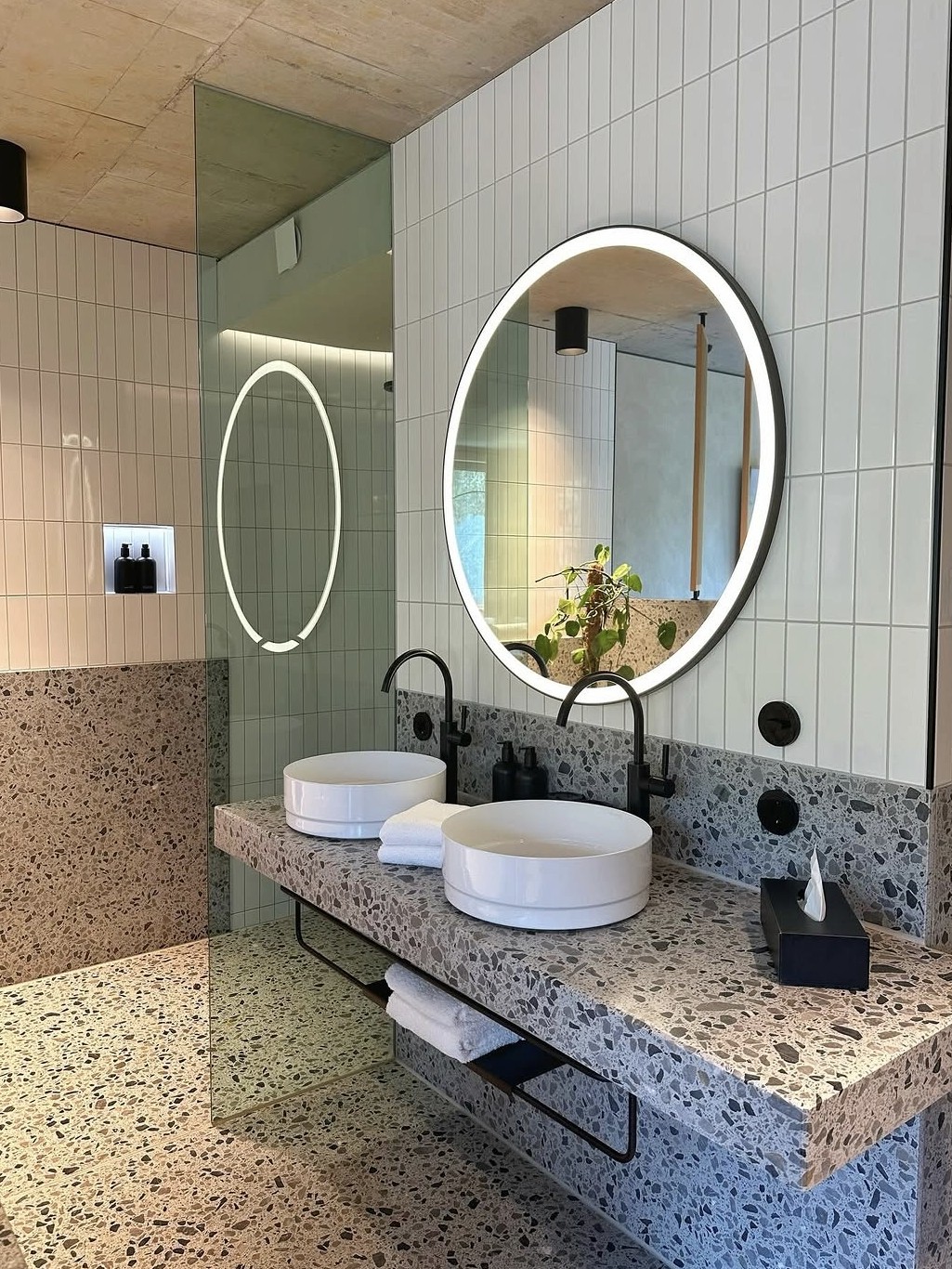 Stilvolles Badezimmer mit runden Spiegeln und Terrazzo-Waschtisch