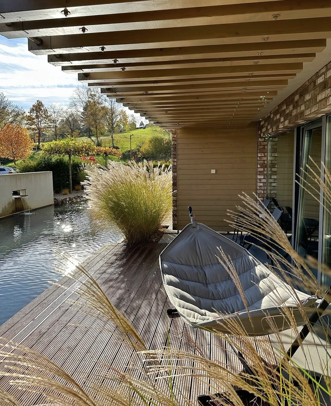 Terrasse mit Hängematte und Naturteich im Außenbereich des Hotels